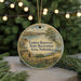 A round ornament with a scenic landscape of a lake, mountains, and a small cabin, surrounded by greenery and twinkling lights.