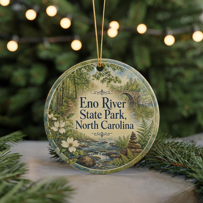 A round ornament with a scenic image of Eno River State Park, North Carolina, featuring a river, trees, and a bridge.