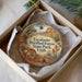 A decorative ornament in a box, featuring a scenic landscape with a desert and mountains, and the text "Escalante Petrified Forest State Park, Utah".