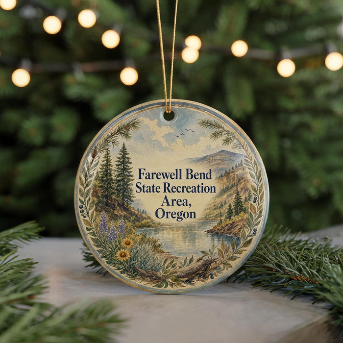 A round ornament with a scenic landscape and text, hanging on a string.