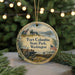 A round ornament with a painting of Fort Columbia State Park, Washington, featuring a lighthouse, a bench, and a boat on the water.