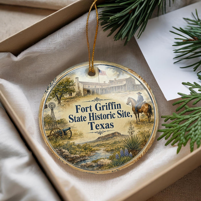A decorative ornament with a painting of Fort Griffin, a historic site in Texas, hanging from a string.