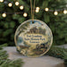 A round ornament with a painting of Fort Loudoun State Historic Park in Tennessee, featuring a cannon, a house, and a river.