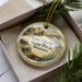 A decorative ornament in a box, featuring a scenic image of Fort Owen State Park, Montana.