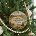 A round ornament hanging on a Christmas tree, featuring an illustration of Fort Kearny, the historic site in Wyoming.
