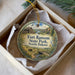A round ornament with a picture of Fort Ransom State Park, North Dakota, and a small building in the background.
