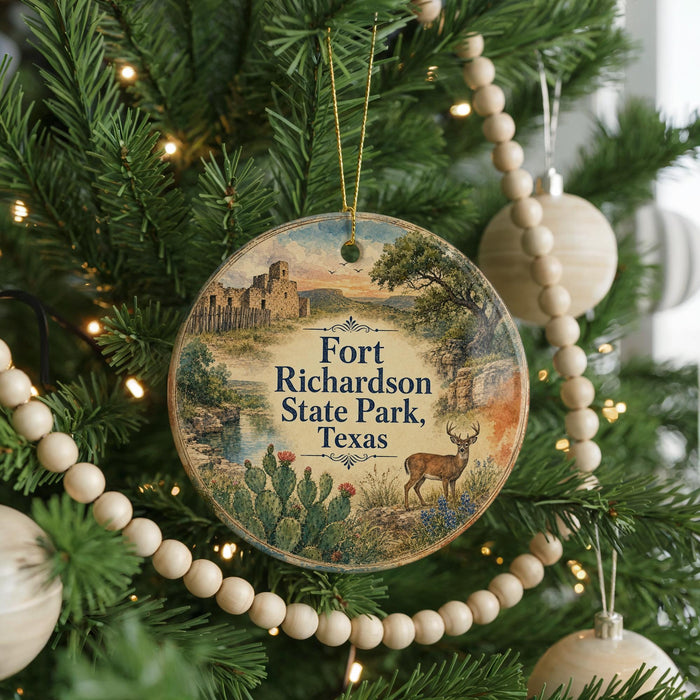 A round ornament hanging on a Christmas tree, featuring a scenic image of Fort Richardson State Park in Texas.