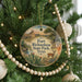 A round ornament hanging on a Christmas tree, featuring a scenic image of Fort Richardson State Park in Texas.