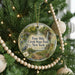 A Christmas tree decorated with ornaments, including a circular ornament with a scenic image of the Four Mile Creek State Park in New York.