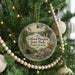 A round ornament hanging on a Christmas tree, featuring a scenic image of the Gifford Pinchot State Park in Pennsylvania.