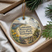 A decorative ornament with a scenic landscape featuring a domed building, trees, and a path, hanging from a string.
