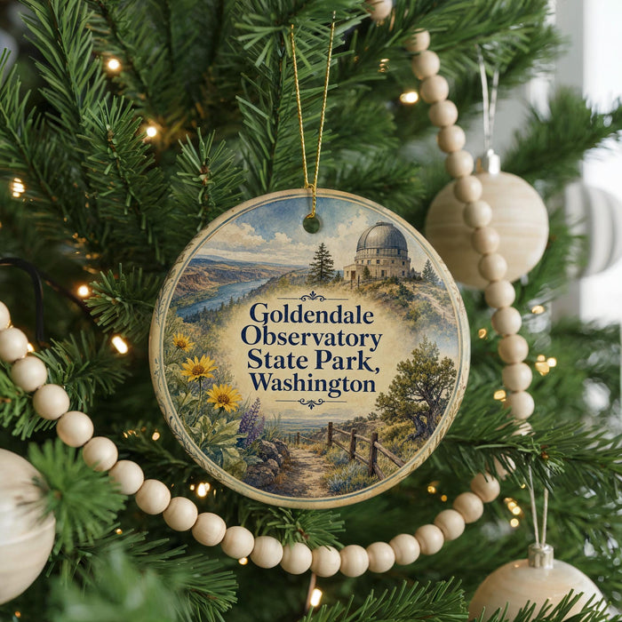 A round ornament hanging on a Christmas tree, featuring a scenic landscape with a dome-shaped building and a path leading to a body of water.