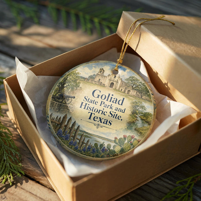 A circular ornament with a painting of a historical site, specifically Goliad State Park and Historic Site, Texas, is displayed in a wooden box.