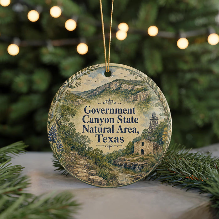 A round ornament with a scenic illustration of the Government Canyon State Natural Area in Texas, surrounded by greenery and a string of lights.
