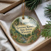 A decorative ornament in a box, featuring a scenic landscape with a deer, trees, and a river.