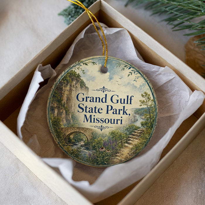 A decorative ornament in a box, featuring a scenic landscape with a bridge and greenery, with the text "Grand Gulf State Park, Missouri" displayed prominently.