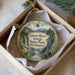 A round ornament with a scenic image of the Green River Gorge State Park in Washington, featuring a waterfall, pine trees, and mountains.