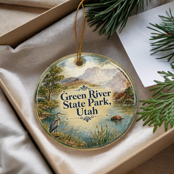 A decorative ornament with a scenic image of the Green River State Park in Utah, featuring a heron and a lake surrounded by mountains.