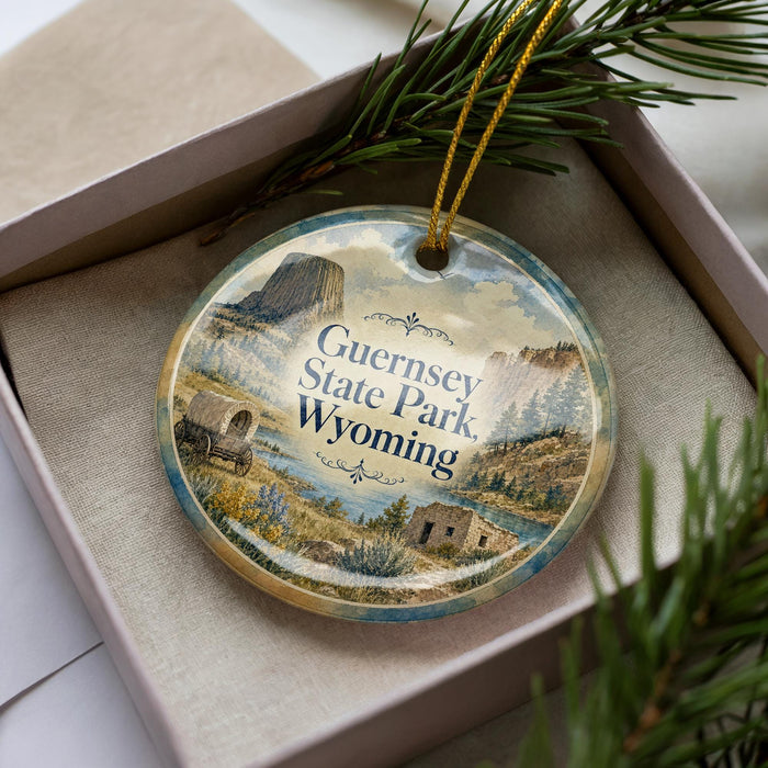 A decorative ornament with a scenic image of Guernsey State Park in Wyoming, featuring a wagon and a mountain landscape.