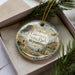 A decorative ornament with a scenic image of Guernsey State Park in Wyoming, featuring a wagon and a mountain landscape.