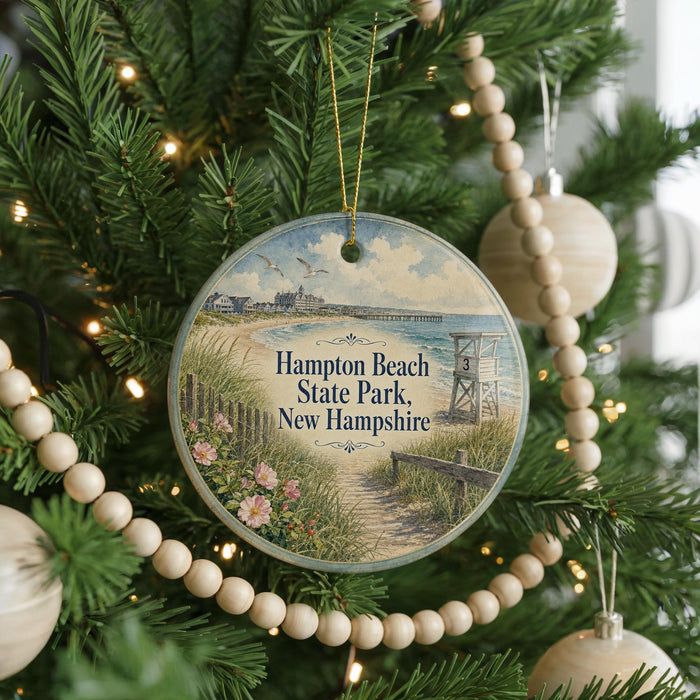 A round ornament hanging on a Christmas tree, featuring a scenic image of Hampton Beach State Park in New Hampshire.
