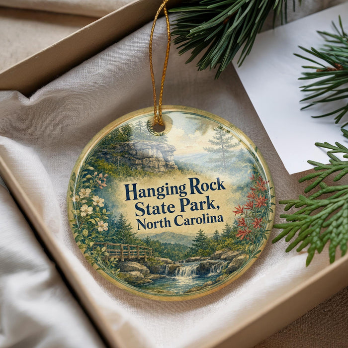 A decorative ornament with a scenic landscape of hanging rock, state park, and water, hanging from a string.