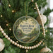 A round ornament hanging on a Christmas tree, featuring a scenic image of Harpeth River State Park, Tennessee.