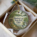 A decorative ornament in a white box, featuring a scenic image of a lake surrounded by trees and a bird, with the text "Harison Lake State Park, Ohio" printed on it.