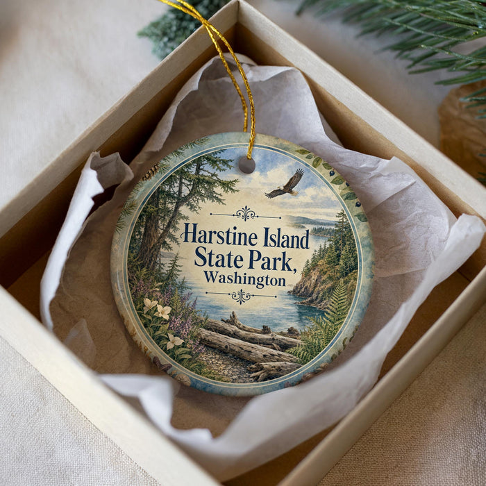 A decorative ornament in a white box, featuring a scenic image of Harstine Island State Park in Washington.