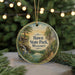 A round ornament with a scenic landscape of Hawn State Park, Missouri, featuring a waterfall and a cabin, is displayed on a table with pine branches in the background.