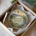 A decorative ornament in a box, featuring a landscape with mountains, a lake, and a bird, along with the text "Heron Lake State Park, New Mexico".