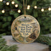 A round ornament with a train and a scenic landscape, hanging on a string.