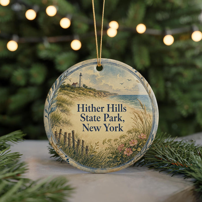 A round ornament with a lighthouse and beach scene, surrounded by greenery and a string of lights.
