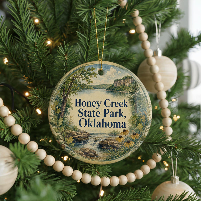 A round ornament hanging on a Christmas tree, featuring a scenic image of Honey Creek State Park in Oklahoma.