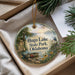 A decorative ornament with a scenic lake and park scene, featuring a boat, a bird, and a sunset.