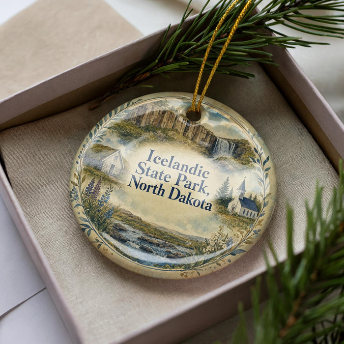 A decorative ornament in a box, featuring a scenic landscape of Iceland, including a castle, mountains, and water.