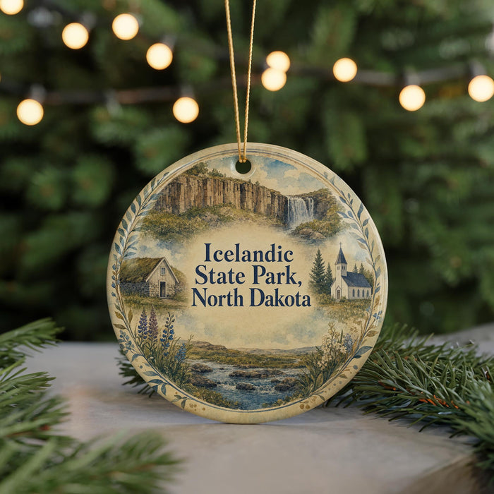 A decorative ornament featuring a scenic landscape of Icelandic State Park, North Dakota, with a waterfall and a church in the background.