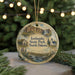 A decorative ornament featuring a scenic landscape of Icelandic State Park, North Dakota, with a waterfall and a church in the background.