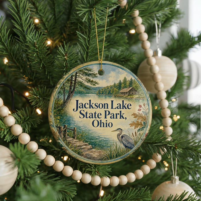 A round ornament hanging on a Christmas tree, featuring a scenic image of Jackson Lake State Park, Ohio.