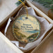 A decorative ornament in a box, featuring a scenic image of Jenessy State Beach in New Hampshire.