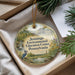 A decorative ornament in a box, featuring a blue jay perched on a branch and a scenic landscape.