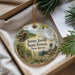 A decorative ornament with a scenic landscape of the Jenny Jump State Forest in New Jersey, featuring a waterfall, pine trees, and a lookout tower.