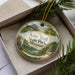 A decorative ornament in a box, featuring an illustration of a bicycle and a bridge, with the text "Katy Trail State Park, Missouri" prominently displayed.