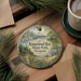A decorative ornament featuring a scenic landscape of Kingsland Bay State Park in Vermont, with pine trees and a body of water in the background.