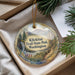 A decorative ornament with a scenic landscape of mountains, waterfalls, and pine trees, hanging from a string.
