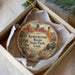 A decorative ornament in a box, featuring a scenic landscape with mountains, trees, and a cabin, along with the text "Kodachrome Basin State Park, Utah".