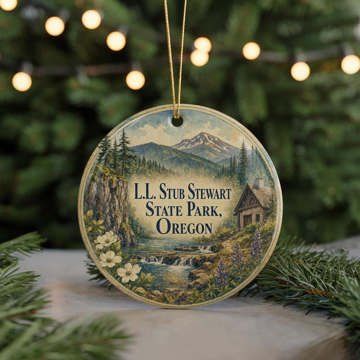A circular ornament with a scenic landscape featuring a mountain, forest, and waterfall, along with the text "LL. STUB STEWART STATE PARK, OREGON".
