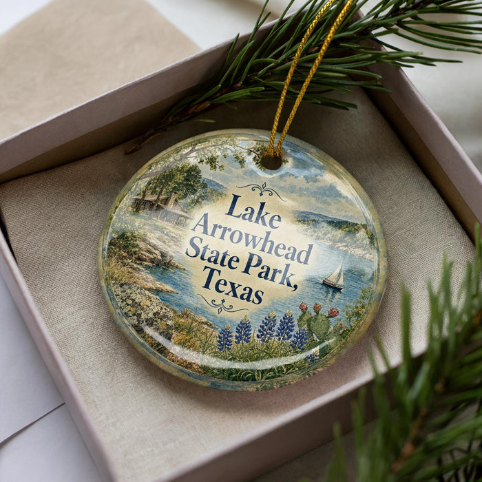 A decorative ornament with a scenic image of Lake Arrowhead State Park, Texas, featuring a sailboat, flowers, and a landscape.