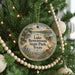 A round ornament hanging on a Christmas tree, featuring a scenic image of Lake Brownwood State Park in Texas.