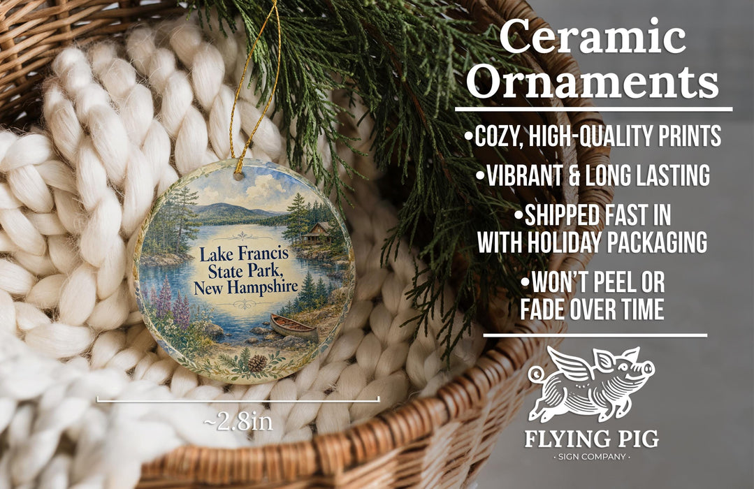 Ceramic ornaments, featuring a scenic image of Lake Francis State Park in New Hampshire, are displayed in a woven basket.